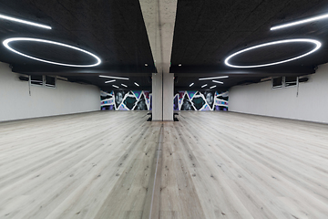 Image showing An empty dance hall with a glass wall adorned with decorative graffiti, offering a fusion of contemporary, urban artistic ambiance and impressive aesthetics.