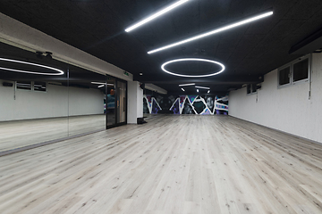 Image showing An empty dance hall with a glass wall adorned with decorative graffiti, offering a fusion of contemporary, urban artistic ambiance and impressive aesthetics.