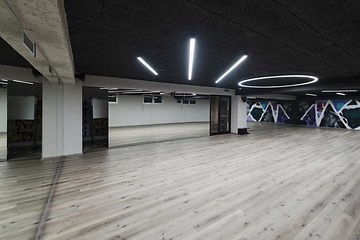 Image showing An empty dance hall with a glass wall adorned with decorative graffiti, offering a fusion of contemporary, urban artistic ambiance and impressive aesthetics.