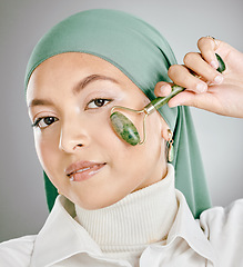 Image showing Muslim arab woman beauty, jade roller and facial skincare, cosmetics product and aesthetic wellness on studio background. Portrait islamic hijab, model face and green stone massage, self care or glow