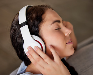 Image showing Woman face, music headphones and peace on living room sofa, relax and freedom, calm lifestyle or mindfulness. Happy young girl listening to meditation audio, radio or sleeping sound in apartment home