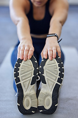 Image showing Woman runner stretching, sports shoes and athlete touching toes on a yoga mat on floor for leg fitness warm up exercise. Female athlete, training for flexibility and healthy cardio running workout