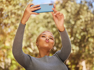 Image showing Black woman, phone and selfie with pout in park with sunshine, summer and happiness by trees. Woman, smartphone and lips in kiss for photo, outdoor and nature with face in happy, funny and relax time