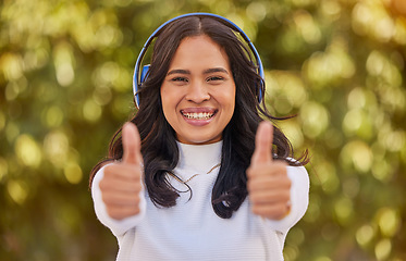 Image showing Thumbs up, relax and woman in park with headphones on listening to music on weekend. Freedom, happiness and portrait of student on holiday, vacation and summer break in nature with wireless earphones