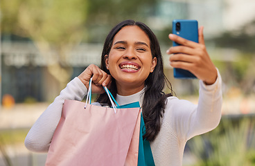 Image showing Phone, selfie and shopping with woman in a city with happy, relax and smiling shopper holding shopping bags. Retail, fashion and social media influencer sharing good news, sale and discount online