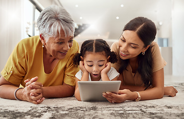 Image showing Grandmother, mother and child with a tablet streaming a movie while relaxing together. Shocked, surprised and happy family watching a online video on social media with digital device in a home