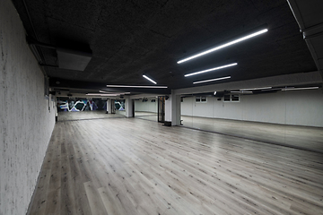 Image showing An empty dance hall with a glass wall adorned with decorative graffiti, offering a fusion of contemporary, urban artistic ambiance and impressive aesthetics.