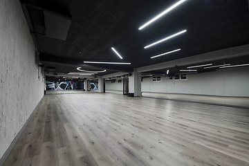 Image showing An empty dance hall with a glass wall adorned with decorative graffiti, offering a fusion of contemporary, urban artistic ambiance and impressive aesthetics.