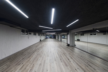 Image showing An empty dance hall with a glass wall adorned with decorative graffiti, offering a fusion of contemporary, urban artistic ambiance and impressive aesthetics.