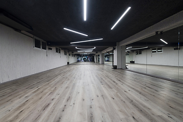 Image showing An empty dance hall with a glass wall adorned with decorative graffiti, offering a fusion of contemporary, urban artistic ambiance and impressive aesthetics.