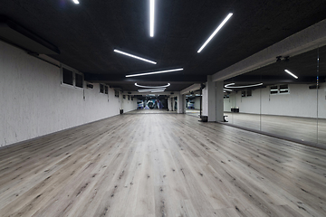 Image showing An empty dance hall with a glass wall adorned with decorative graffiti, offering a fusion of contemporary, urban artistic ambiance and impressive aesthetics.