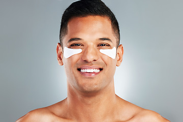 Image showing Happy, beauty and eye patches on a grey studio background. Skincare, health and man model with face and facial cosmetics strip or collagen pads for skin wellness, hydration or facial anti aging