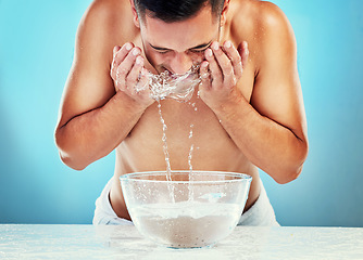 Image showing Skincare, cleaning and man with water on face satisfied with hydration, grooming and hygiene. Wellness, cleansing and healthy routine of model for hydrated skin on blue studio background