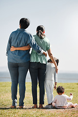 Image showing Park, nature and back view of family on grass outdoors with relatives spending quality time together. Love, support and caring grandma, mom and girl with baby bonding together with scenic ocean view.