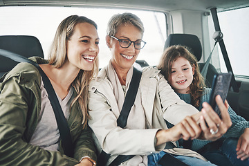 Image showing Phone, selfie and happy family in a car for a road trip driving or traveling to a holiday vacation adventure together. Grandma, mother and excited girl or child enjoy pictures for a fun weekend