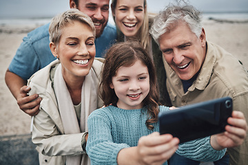 Image showing Family, girl and phone selfie on beach holiday adventure spending time with parents and grandparents. Men, women and child smile in Australia, happy fun on winter hike by sea and photo on smartphone