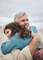 Image showing Happy, beach and grandfather hug a girl at the sea together on holiday. Happiness, love and elderly man in retirement smile, embracing and bonding with his toddler grandchild or kid on vacation