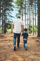 Image showing Grandfather, child and hold hands for walk in forest, nature or woods together for bonding. Man and kid by trees, sunshine and summer for walking, fun and happiness on vacation with family