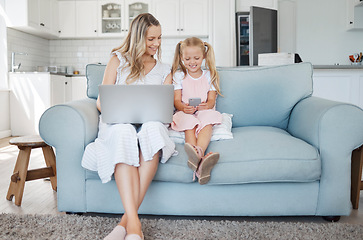 Image showing Technology, child and mother learning on a mobile app, working on a laptop and happy on the internet on the sofa in their house. Girl and mom streaming comic video on a phone with computer for work