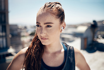 Image showing Fitness, earpods and woman in the city for outdoor workout while listening to music, podcast or radio. Training, exercise and girl athlete streaming a song or audio for sports motivation on rooftop.