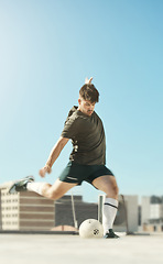 Image showing Man, soccer ball and kick in city for goal, shooting or workout on rooftop of building, urban or metro. Soccer player, football and striker at training, exercise and fitness in sports in summer sun