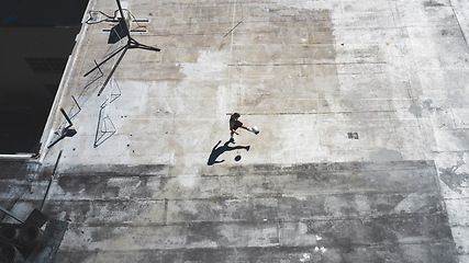 Image showing Top view, soccer player and man in fitness, training and workout practice on city building rooftop in Portugal. Sports athlete, football player and person with soccer ball in health wellness exercise