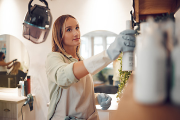 Image showing Woman, shelf and salon while looking at product, shampoo and spray at work in hair care, beauty and packing. Small business owner, hairdresser and entrepreneur in store, startup and arrange cosmetics