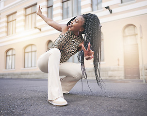 Image showing Black woman, street fashion and peace hand sign in city, squat and tongue out in unique self expression. Gen z, trendy and cool, creative and urban girl from Nigeria with stylish designer clothes.