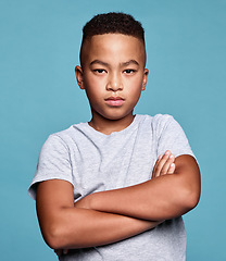 Image showing Problem, crossed arms and portrait of child with angry facial expression, attitude and upset over conflict on mockup studio. Anger, moody boy and unhappy African youth kid isolated on blue background