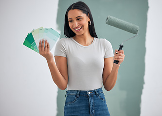 Image showing Home renovation, painting and woman with a choice of color for a wall in a room of her house. Happy, creative and young painter doing art design, maintenance and working on her home with paint