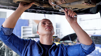 Image showing Mechanic, engineer and car with a man at work in a garage or service center for the transport industry. Workshop, auto and repair with a young male repairman working on a vehicle for maintenance