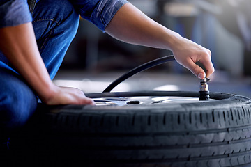 Image showing Air pressure, tire and mechanic working in garage with pump in hand. Man in auto service, vehicle care and checking car wheel in workshop. Technician doing maintenance check in motor repair industry