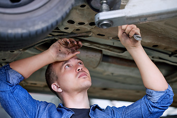 Image showing Car service, repair and mechanic working on car in the garage or workshop. Motor care, engineer and repairman standing under vehicle with wrench doing inspection, maintenance and fixing automobile