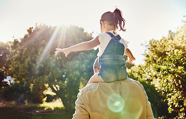 Image showing Back, child and father walking in a park for freedom, care and love together in summer. Girl and dad on an adventure walk in nature, garden or backyard while carrying kid on shoulders with flare
