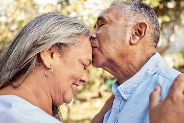 Image showing Senior couple, love and forehead kiss for care, passion and embrace for romantic relationship together in nature. Happy elderly man and woman in retirement with smile for romance kissing and hugging