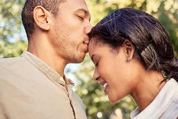 Image showing Kiss, forehead and couple in a park to relax, peace and calm together in nature. Young, happy and man with love and care for woman kissing and giving affection to show gratitude on a date in a garden