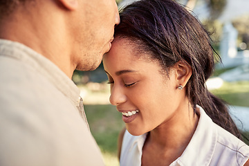 Image showing Couple, love and outdoor park for bonding with a kiss on forehead showing commitment, trust and support with a smile. Happiness, care and nature with a young man and woman in a romantic relationship