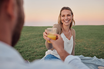 Image showing Toast, juice and couple on a date in a park for love in marriage together during summer. Happy, smile and young woman cheers with a drink and a man on a picnic in nature for happiness and peace