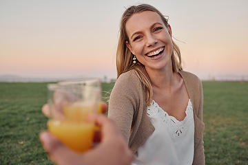 Image showing Cheers, juice and portrait of a happy woman in nature on an outdoor picnic in a garden with a summer sunset. Happiness, smile and pov of a lady toasting with a orange drink while on a romantic date.