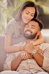 Image showing Couple, man and black woman on sofa for hug, love and care in living room to relax while happy. Black man, woman and marriage for romance, embrace and smile together on couch in lounge with happiness