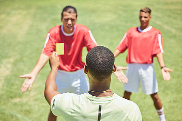 Image showing Soccer, team and referee with yellow card, booking and foul a player on a grass pitch or field during a game. Fitness, football and discipline with a man ref giving a caution during a sports match