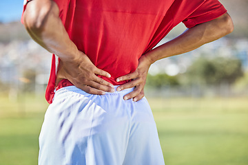 Image showing Field, soccer and man with back injury in game tournament with pain, inflammation and backache. Football, athlete and accident in match with player holding body muscle for pressure relief.