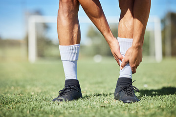 Image showing Sports, soccer and ankle injury on grass with self assessment of physical pain at athlete game. Hurt, injured and joint discomfort of football man on field checking painful leg at competition.