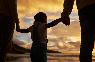 Image showing Parents, child and silhouette of holding hands on the beach during sunset for family bonding in the outdoors. Kid hand, mother and father enjoying the scenic view, care and freedom on the ocean coast