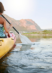 Image showing Woman rowing a kayak or boat on a river or lake while on summer vacation or travel. Tourist explore nature on water during a tropical adventure kayaking in the wildlife on summer holiday or vacation