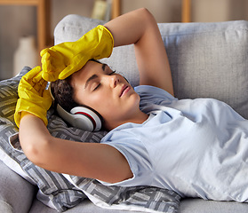 Image showing Sofa, headphones and woman cleaner sleep, relax and listening to music after cleaning work in home living room. Calm, tired and fatigue girl on a couch in her lounge with audio streaming service app