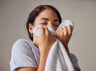 Image showing Woman smelling a clean towel after doing laundry at her home, hotel or resort while spring cleaning. Housekeeping, maid or housewife doing washing for maintenance, hygiene and fresh fabrics or cloth.