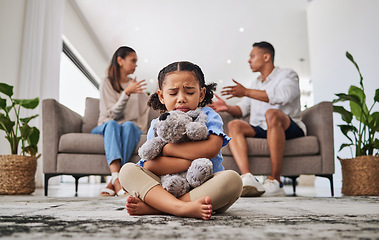 Image showing Parents, fighting and sad girl in living room with teddy bear for support or comfort. Family, divorce and husband in argument with wife and scared kid sitting in fear, stress or depression on carpet