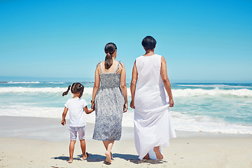 Image showing Children, family and beach with a girl, mother and grandmother enjoying the sea or ocean view while on vacation. Kids, bonding and travel with a woman, parent and daughter on the sand on holiday