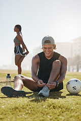 Image showing Friends, sport and fitness, stretching on grass with soccer ball, warm up for exercise and workout outdoor in park. Young man tying shoe lace, black woman and sports training with body wellness.
